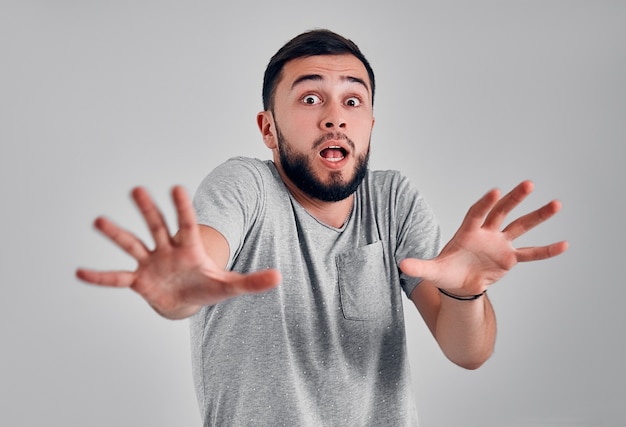 I'm afraid. Fright. Portrait of the scared man.Man standing isolated on gray studio background. Male half-length portrait. Human emotions, facial expression concept. Front view