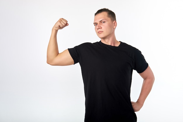 I'm strong. Portrait of handsome brunet wearing black shirt demonstrating biceps triceps.