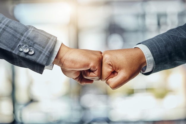 I support you every step of the way Shot of two unrecognizable lawyers giving each other a fist bump at work