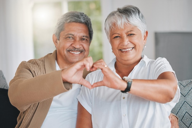 I wrote your name in my heart and forever it will stay Portrait of a senior couple making a heart shape with their hands at home