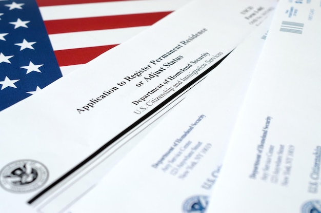 I485 Application to register permanent residence or adjust status blank form lies on United States flag with envelope from Department of Homeland Security