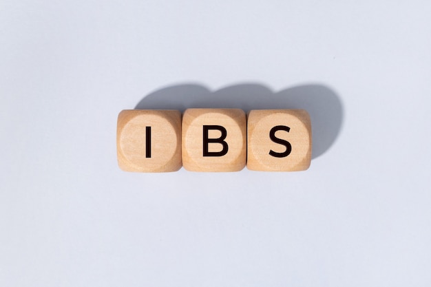 IBS word on woden blocks isolated on gray background. Irritable Bowel Syndrome