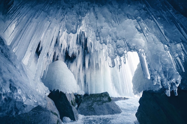 Ice cave with icicles and ice splashes on Baikal lake Winter landscape of Baikal lake Russia