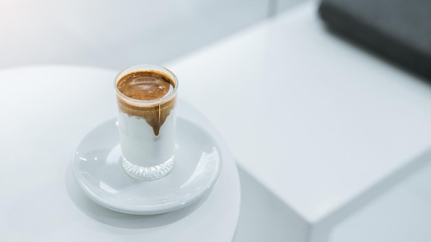 Ice coffee on a table with cream being poured into it showing the texture and refreshing look of the