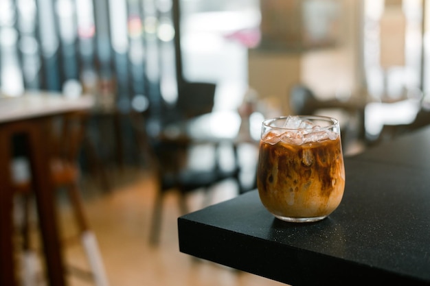 Ice coffee on a table with cream being poured into it showing the texture