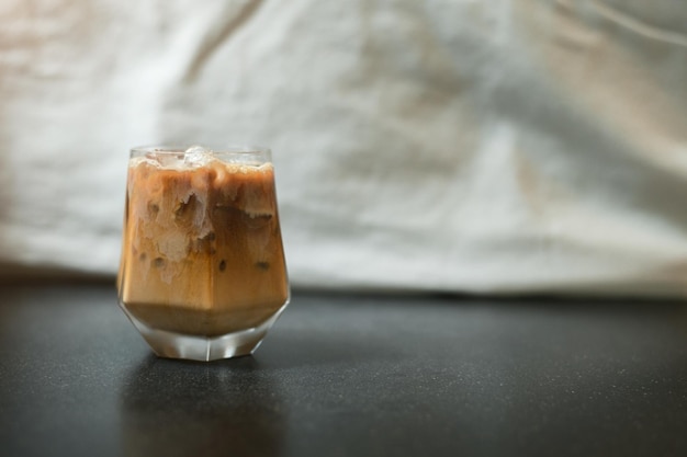 Ice coffee on a table with cream being poured into it showing the texture