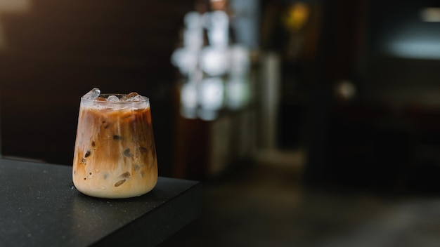 Ice coffee on a table with cream being poured into it showing the texture