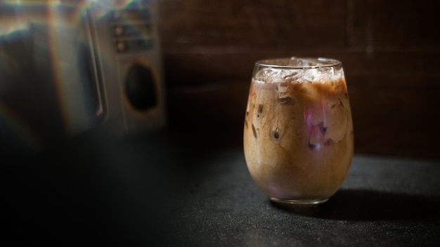 Ice coffee on a table with cream being poured into it showing the texture