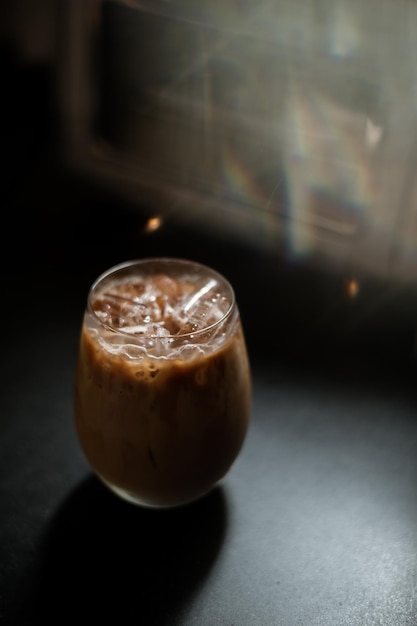 Ice coffee on a table with cream being poured into it showing the texture