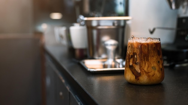 Ice coffee on a table with cream being poured into it showing the texture