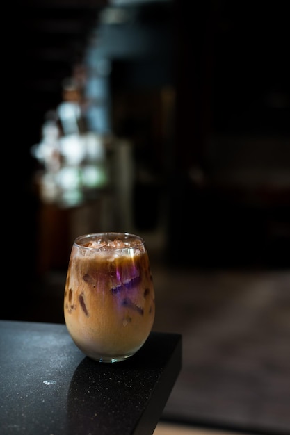 Ice coffee on a table with cream being poured into it showing the texture