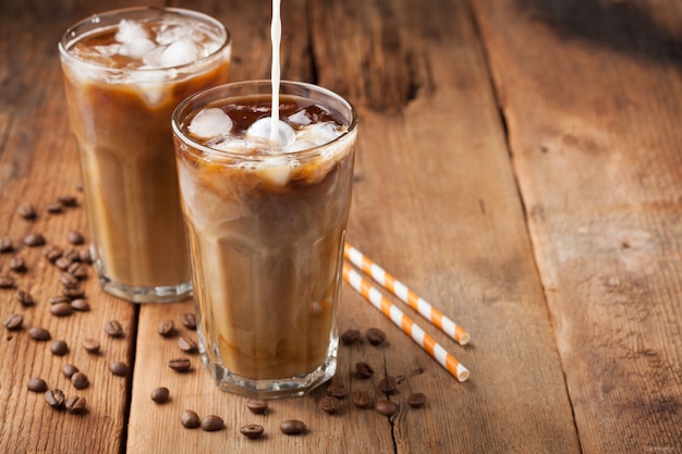 Ice coffee in a tall glass with cream