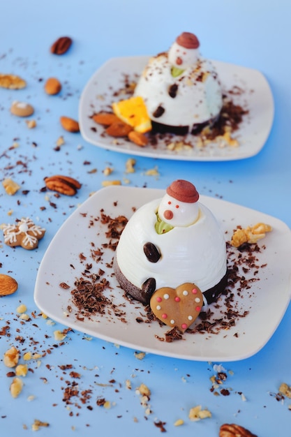 Ice cream background in the shape of two edible snowmen on white plates close up. Top view. dessert