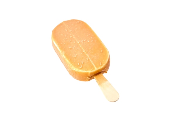 Ice cream in caramel glaze on a wooden stick isolated on white