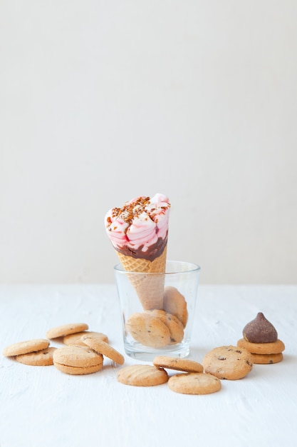 ice cream cone on the glass with cookies and chocolate wafer cone with cream and chocolate cookies