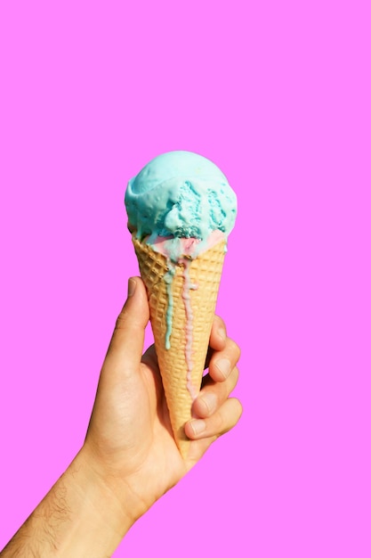 Ice cream cone in hand on minimal color background isolated Summer food sweets ice cream concept