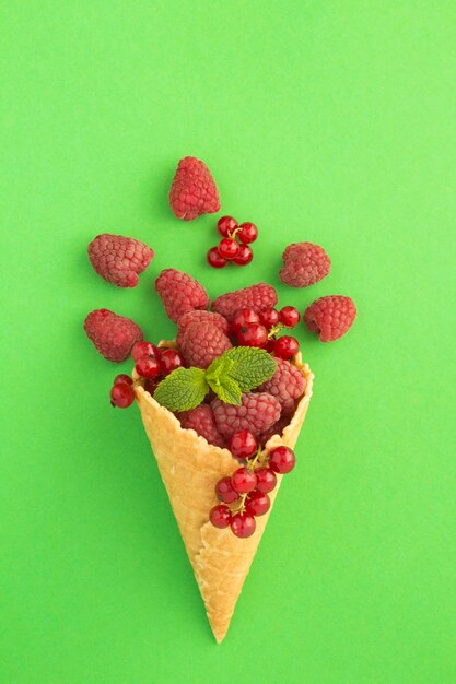 Ice cream cone with raspberries and red currants