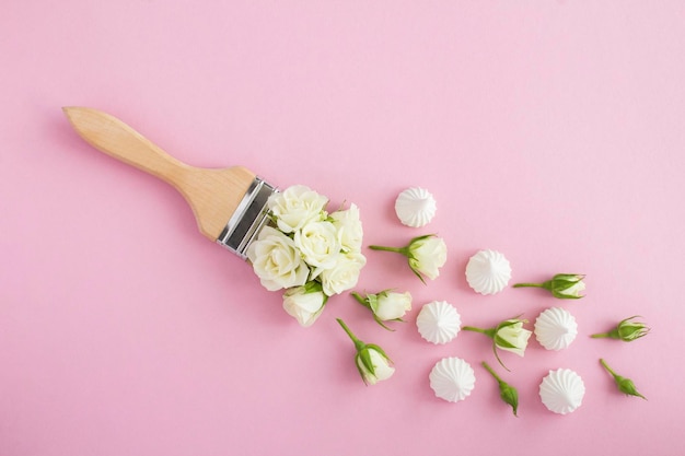 Ice cream cone with white roses and meringue the pink background Top view Copy space