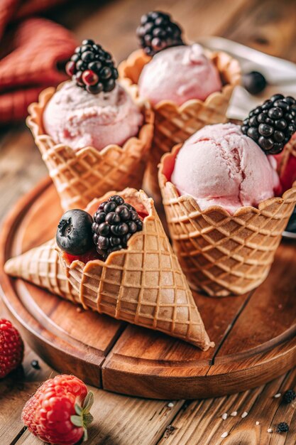 ice cream cones with berries on them one of them has a black berry on the top