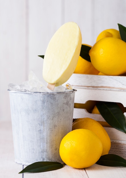 Ice cream made from lemon frozen juice sherbet in still bucket and box of raw lemons