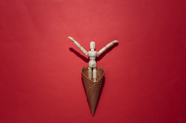 Ice cream waffle cone with  puppet on red bright background. Top view