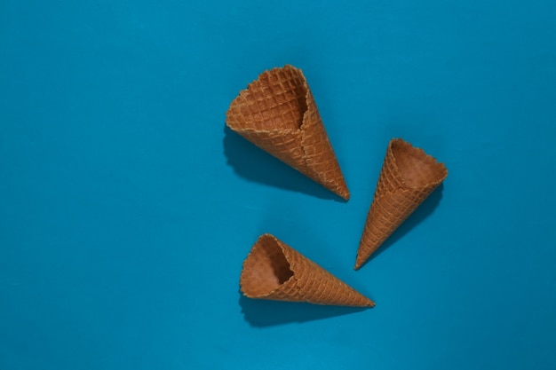 Ice cream waffle cones on blue bright background. Top view