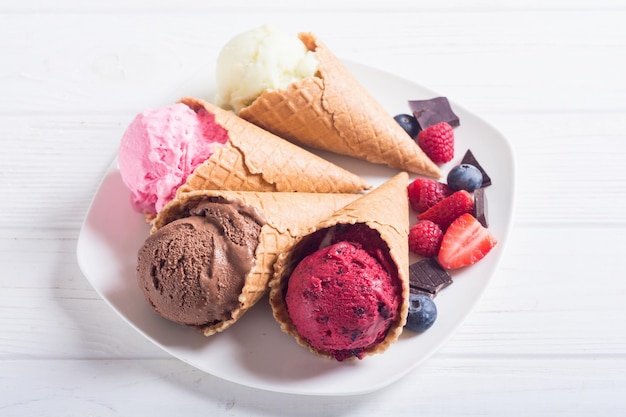 Ice cream waffle cones with berries chocolate and vanilla