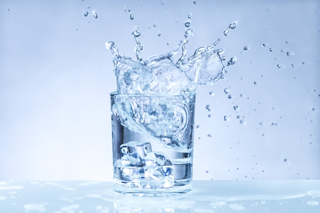 Ice cube falling into a glass of water