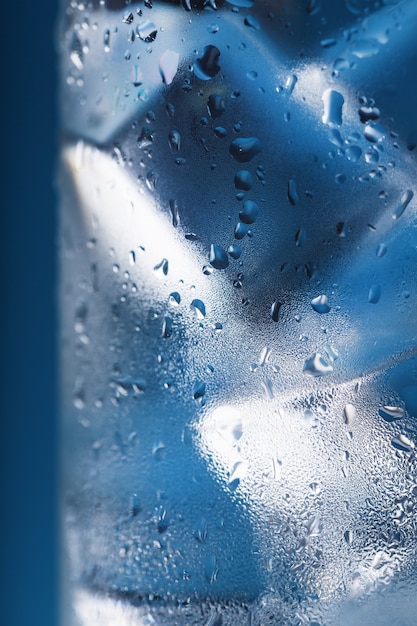 Ice cubes in a misted glass with drops of ice water closeup macro