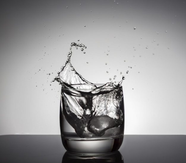 Ice cubes splashing in glass of water