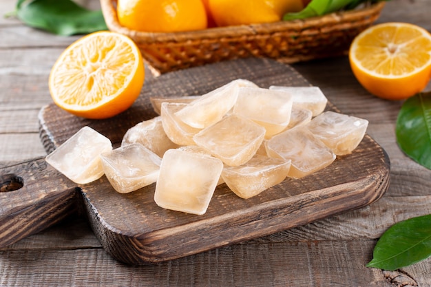 Ice cubes with lemon in tray on a wooden table, closeup