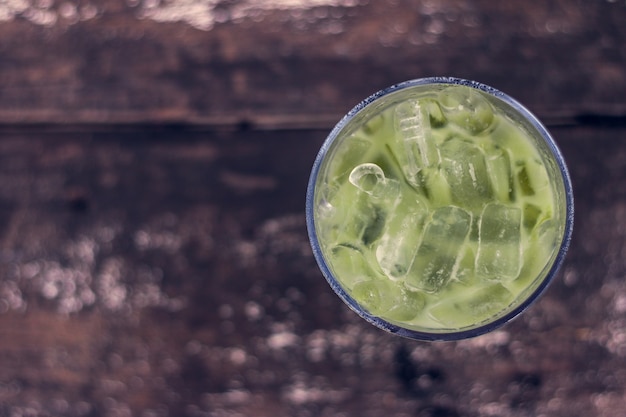 Ice green tea in glass on wood table 