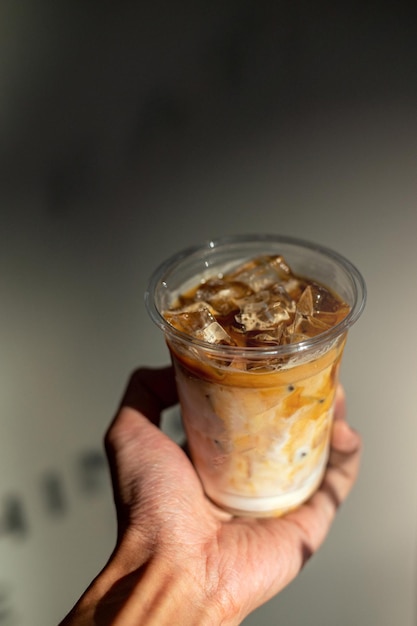 ice latte coffee in plastic glass on black table at cafe