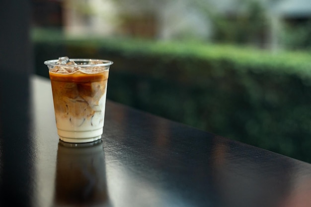 ice latte coffee in plastic glass on black table at cafe