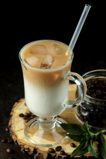 Ice latte or Iced coffee with milk and ice cubes in a glass beaker against a dark background. refreshing drink. summer drink.