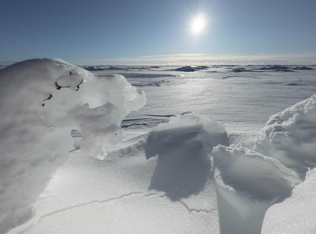 Ice slopes in sunny winter day, transparent ice of blue color, purely blue sky, long shadows, a pure snow-covered virgin soil, snow barkhans, . High quality photo