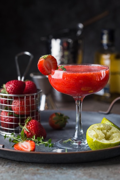 Ice Strawberry alcohol cocktail with lime and rum in a glass