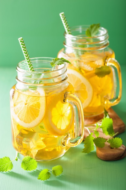 Ice tea with lemon and melissa in mason jars