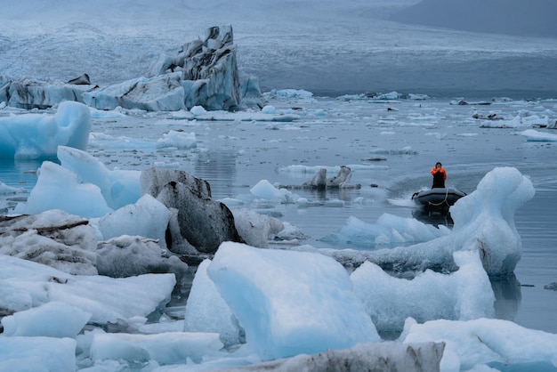 Icebergs in jokulsarlon and boat with blurred man