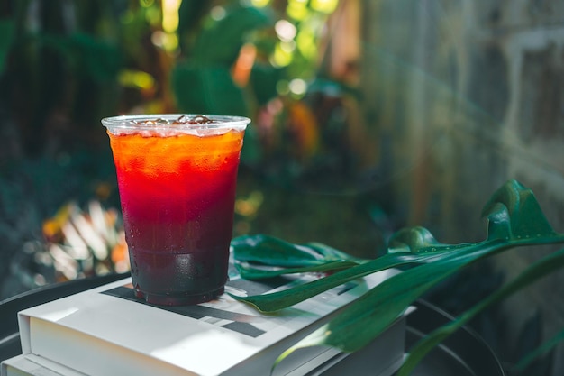 Iced Americano coffee or black coffee in plastic glass on a wooden table in the garden