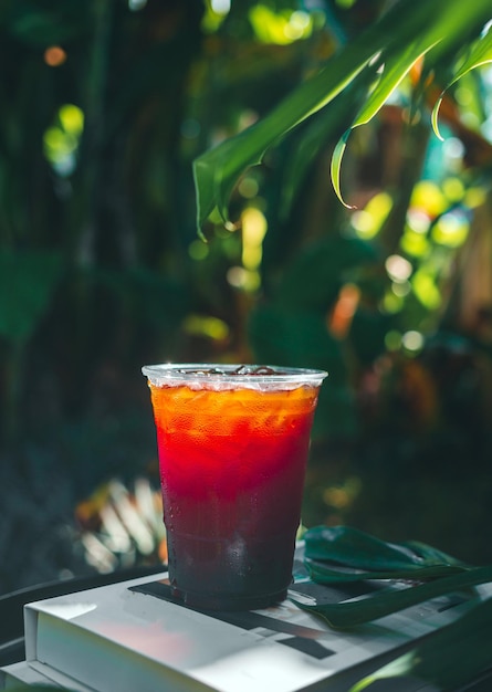 Iced Americano coffee or black coffee in plastic glass on a wooden table in the garden