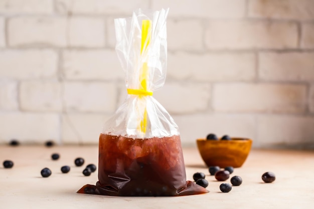 Iced Blueberry Bubble Tea with straw and raw fruit served in disposable pack isolated on table top view of healthy morning drink