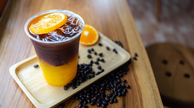 Iced coffee drink menu Orange Americano with fresh orange fruit mixed in a plastic cup