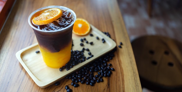 Iced coffee drink menu Orange Americano with fresh orange fruit mixed in a plastic cup