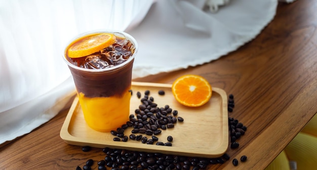 Iced coffee drink menu Orange Americano with fresh orange fruit mixed in a plastic cup