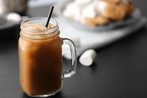 Iced coffee in glass jar on black table