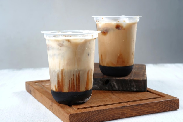 iced coffee in a plastic cup on white and grey background