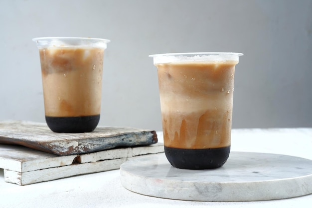 iced coffee in a plastic cup on white and grey background