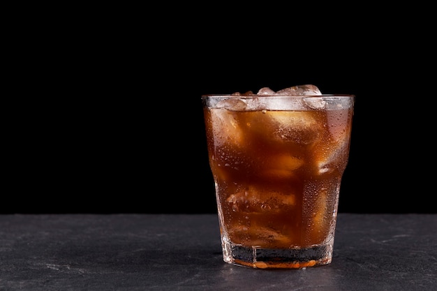 Iced coffee with ice in transparent misted glass