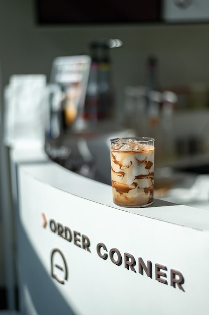 Iced coffee with milk in a glass on the bar counter